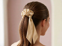 Golden Hour champagne silk scrunchie styled in a sleek ponytail