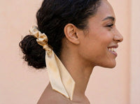 Golden Hour champagne silk scrunchie styled in a low bun