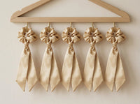 Golden Hour champagne silk scrunchies on a boutique wall display