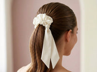 Gala ivory silk scrunchie styled in sleek high ponytail with ribbon tails together