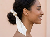 Gala ivory silk scrunchie in low messy bun with ribbon tails together
